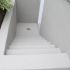 Finition en crépi acrylique sur descente d’escalier en béton extérieur.