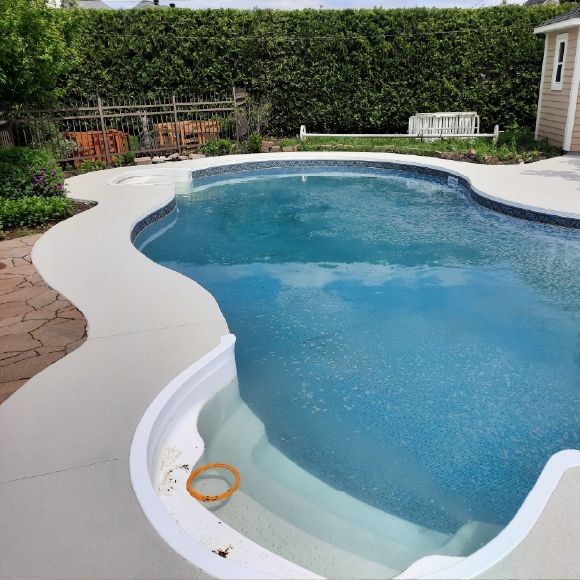 Rénovation complète du contour d’une piscine en béton avec revêtement acrylique.