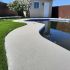Finition acrylique haut de gamme pour contour de piscine en béton.