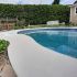 Application de crépi acrylique sur un contour de piscine en béton.