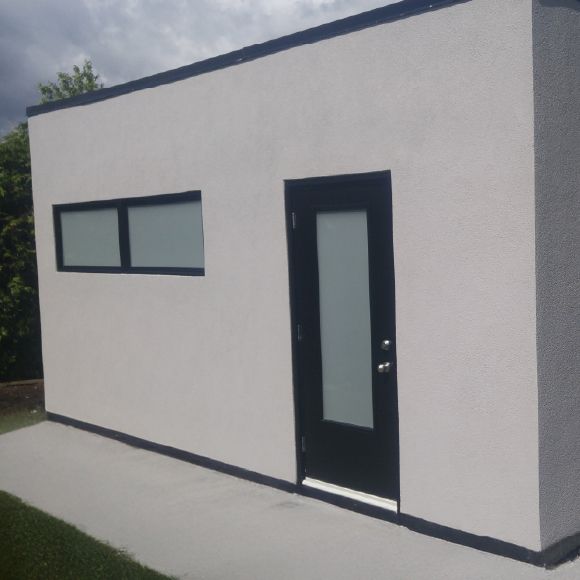 Application du revêtement extérieur pour un cabanon avec du crépi acrylique