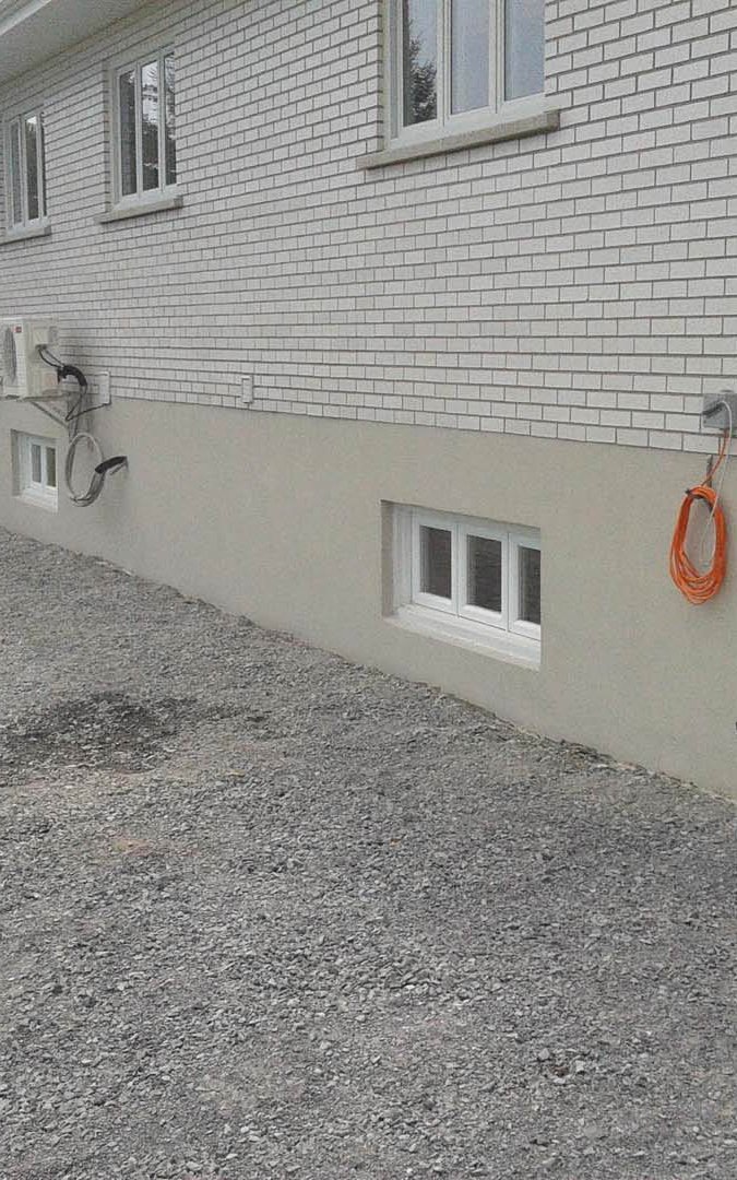 Réparation et finition de crépi acrylique sur une maison à Sainte-Thérèse.